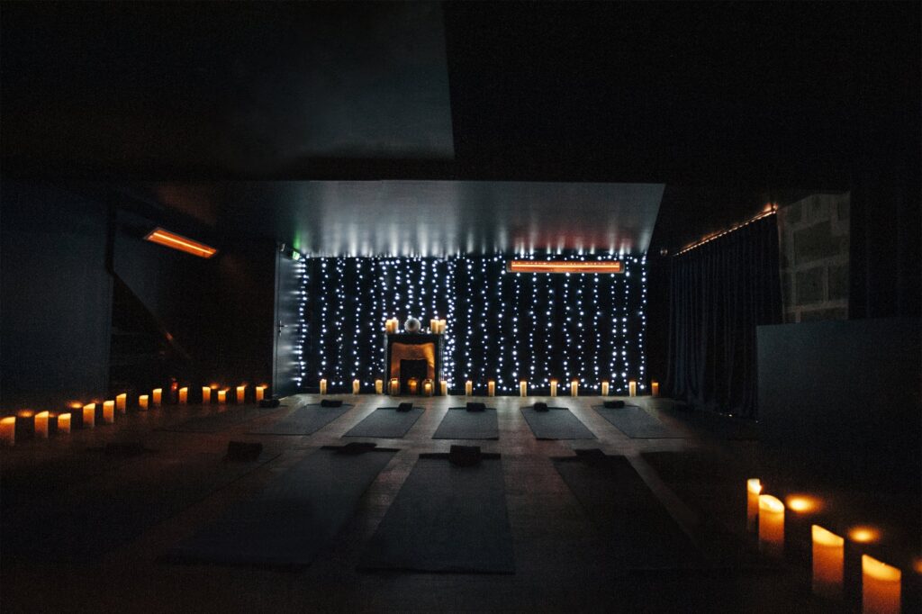 Darkened Yoga studio lit by candlelight